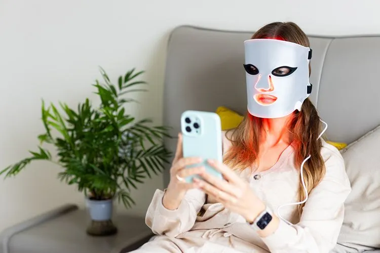Woman using CurrentBody LED mask at home